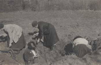 Women searching a bomb crater for souvenirs in France Photograph